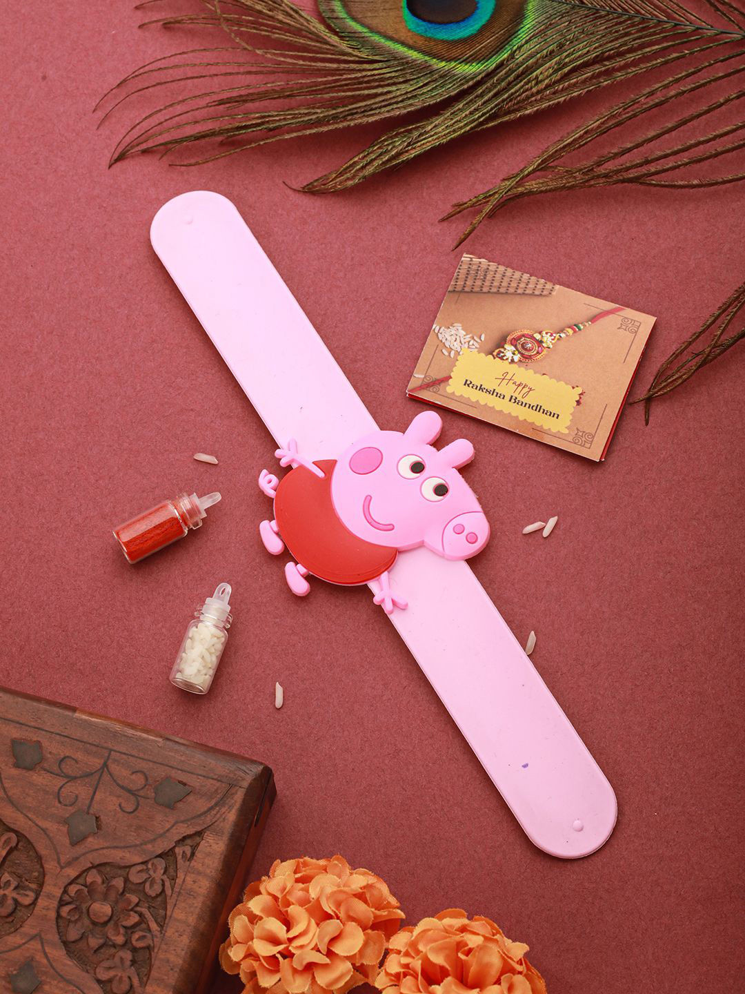 

Saraf RS Jewellery Peppa Pig Wrist Slap Band Rakhi With Roli Chawal & Greeting Card, Pink