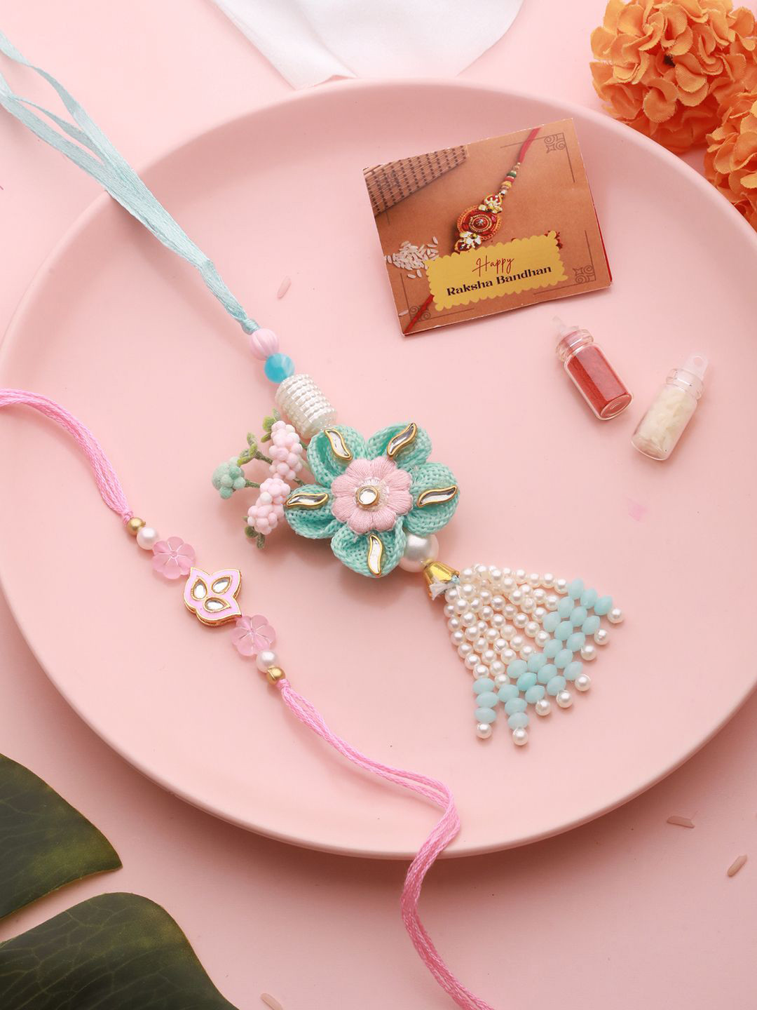 

Saraf RS Jewellery Set Of 2 Flower & Pearl Beaded Rakhi with Roli Chawal & Greeting Card, Pink