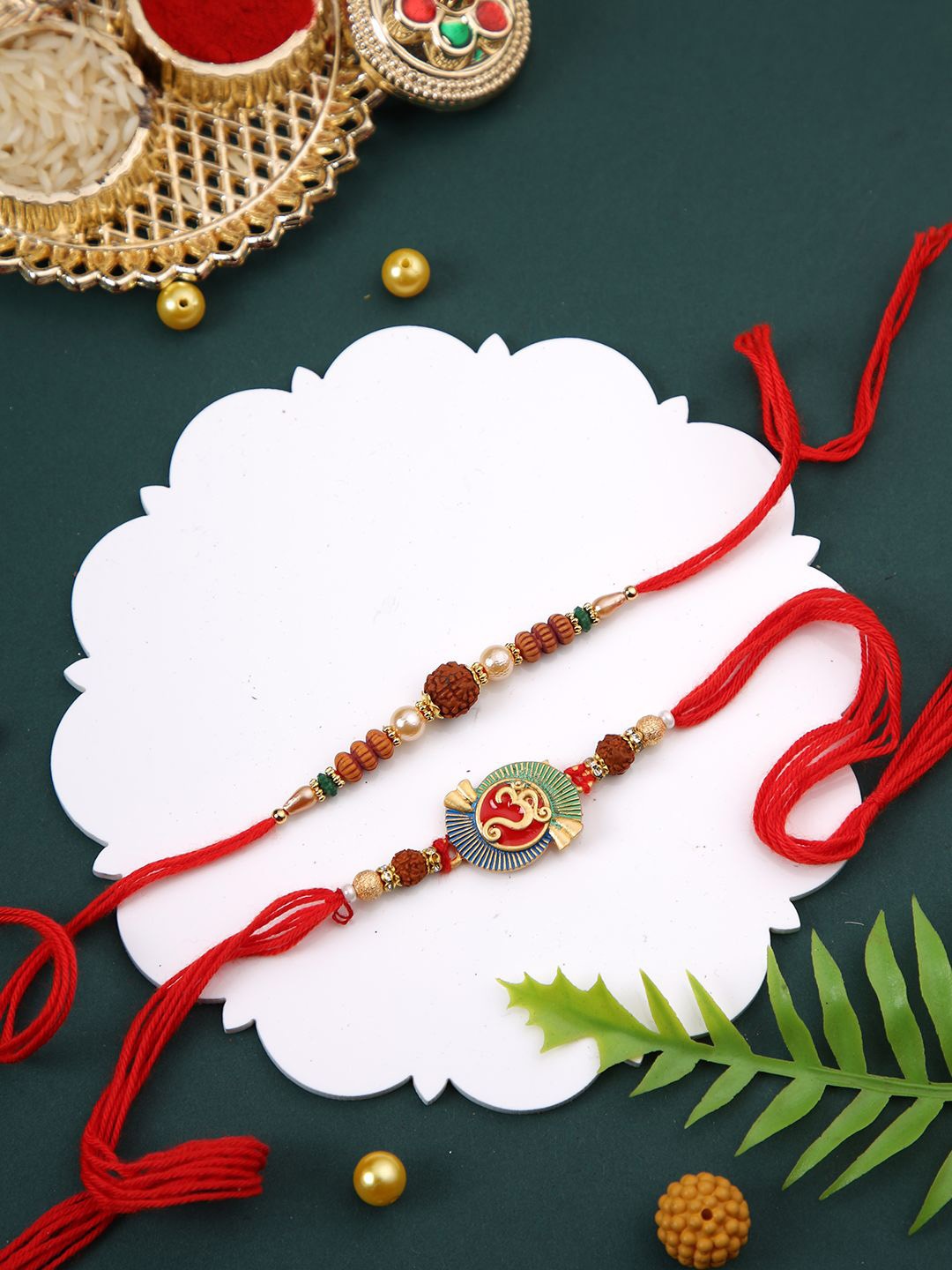

Aapno Rajasthan Set Of 2 Rudraksh & Om Beaded Rakhi With Roli Chawal & Greetings Card, Red
