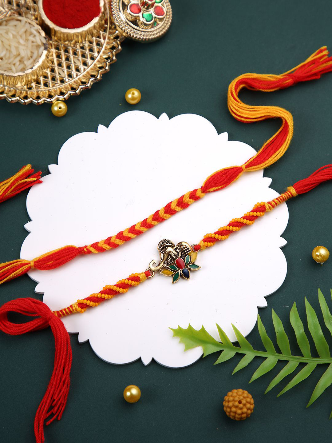 

Aapno Rajasthan Set of 2 Braided Multistrand Rakhis With Roli Chawal & Greetings Card, Red
