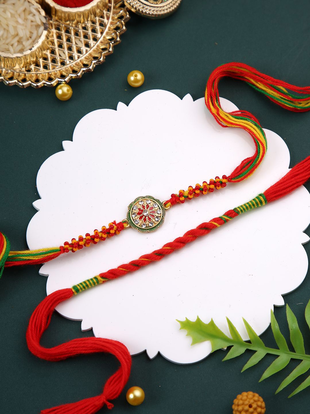 

Aapno Rajasthan Set of 2 Floral Rakhis With Roli Chawal & Greetings Card, Red