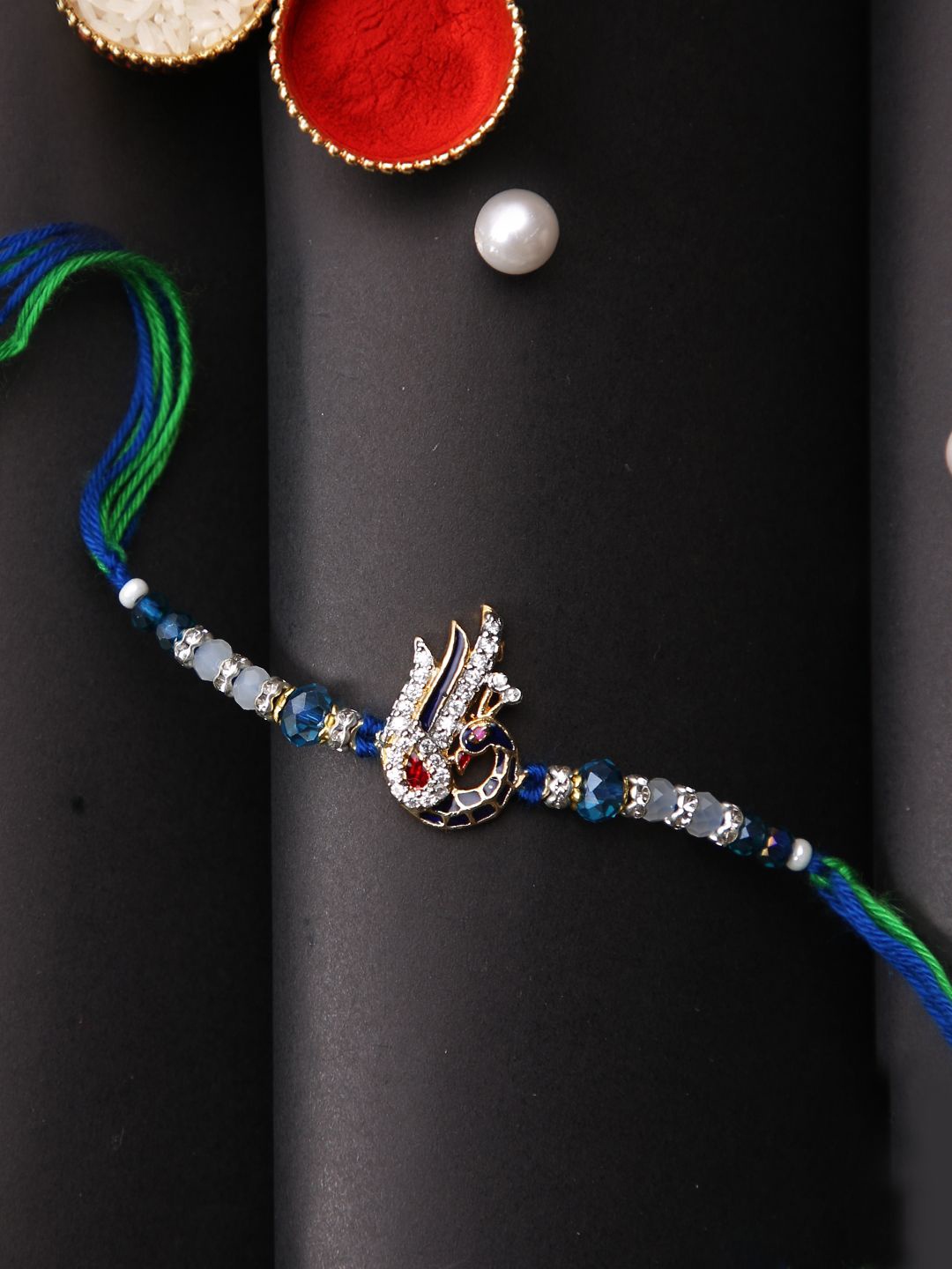 

Aapno Rajasthan Stone Studded Peacock Multistrand Rakhi With Roli Chawal & Greetings Card, Silver
