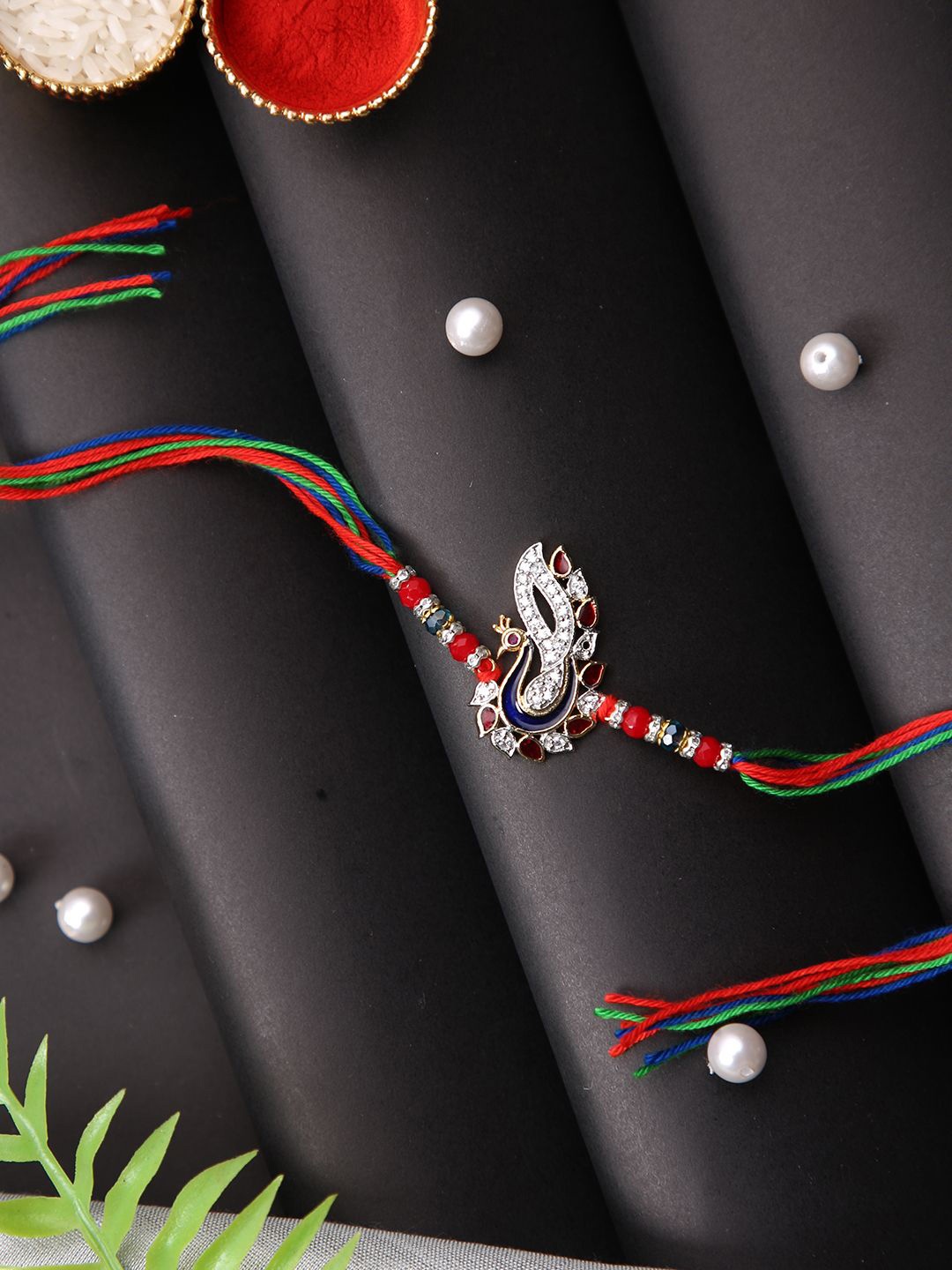 

Aapno Rajasthan Stone Studded Peacock Multistrand Rakhi With Roli Chawal & Greetings Card, Silver