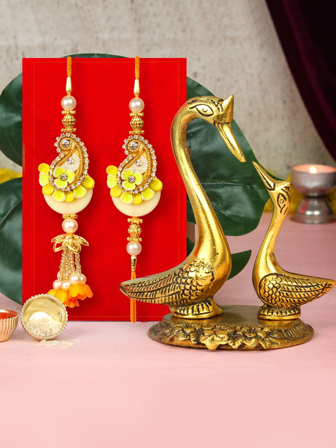 

Tied Ribbons Set of 2 Rakhi, Swan Couple Statue, Card & Roli Chawal Set, Yellow