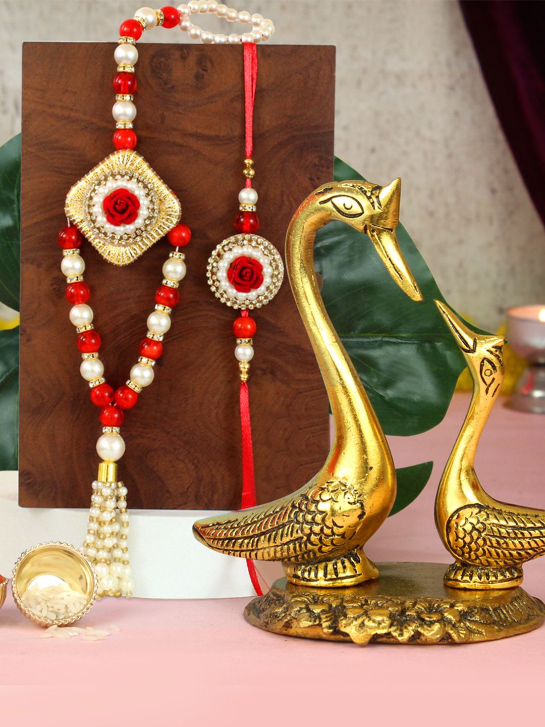 

Tied Ribbons Set of 2 Bhaiya Bhabhi Rakhi, Swan Couple Statue & Roli Chawal Gift Set, Red