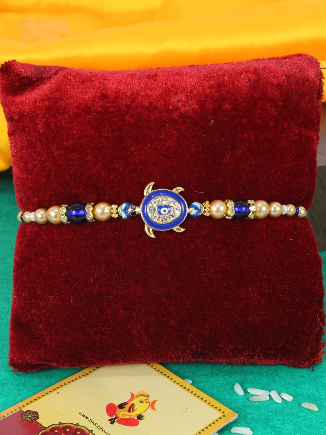 

TIED RIBBONS Evil Eye Rakhi with Greeting Card & Roli Chawal, Blue