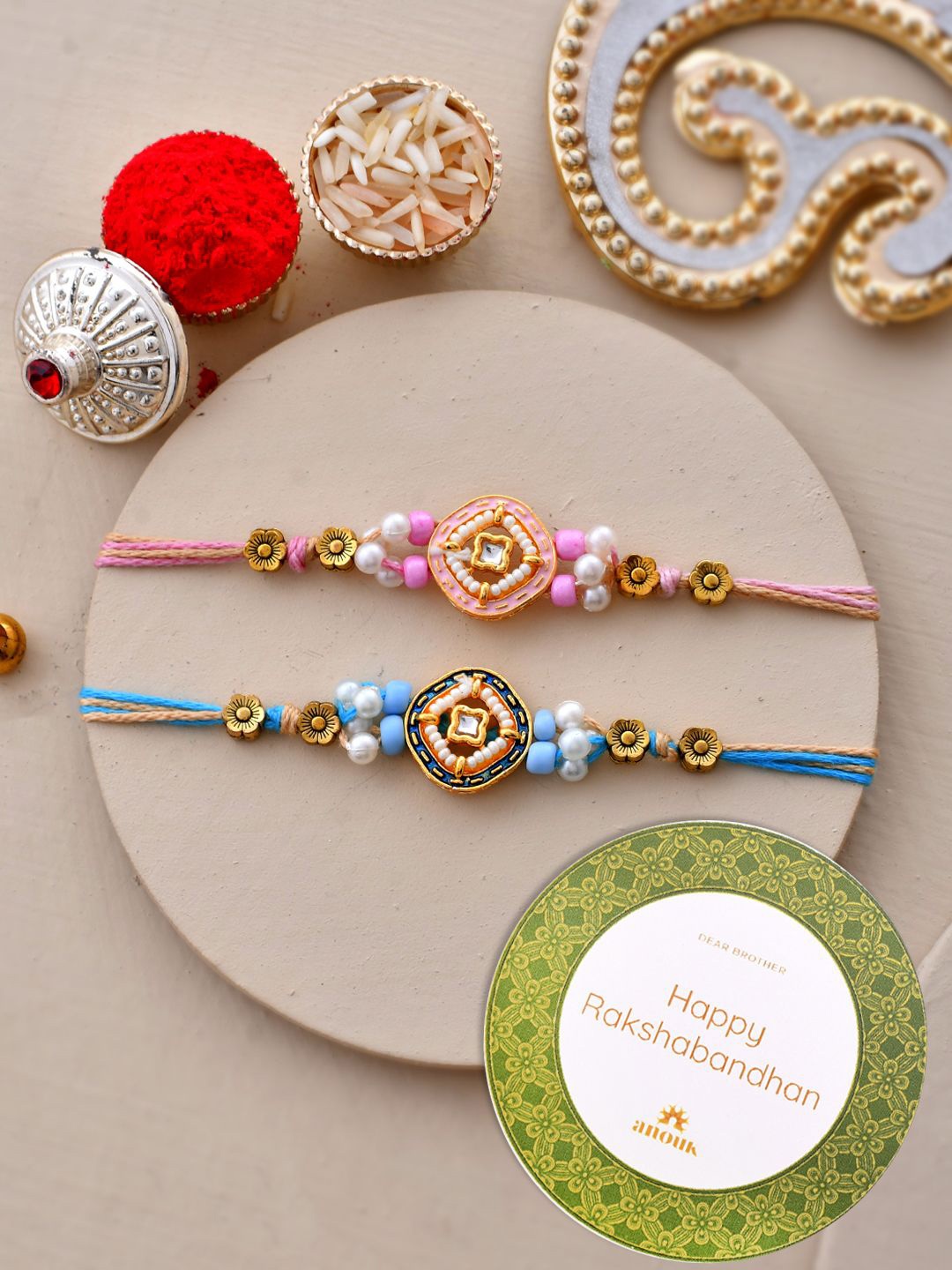 

Anouk Set Of 2 Kundan Studded Thread Rakhi With Roli Chawal & Greetings Card, Blue