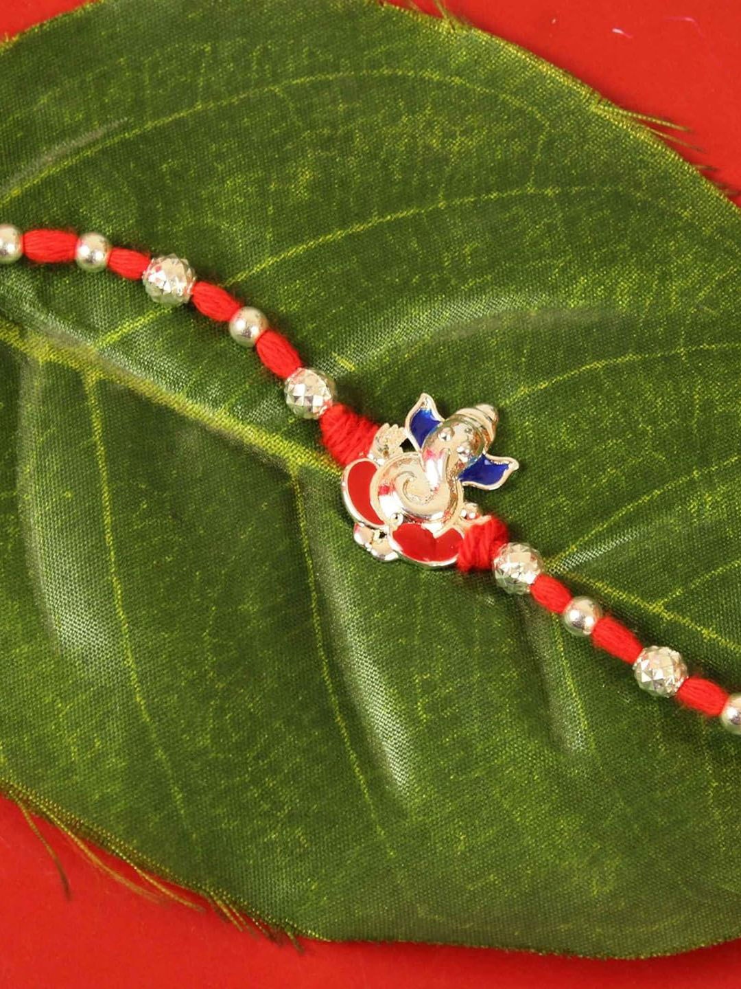 

Tied Ribbons Silver Ganesh Rakhi, Card & Roli Chawal Set, Orange