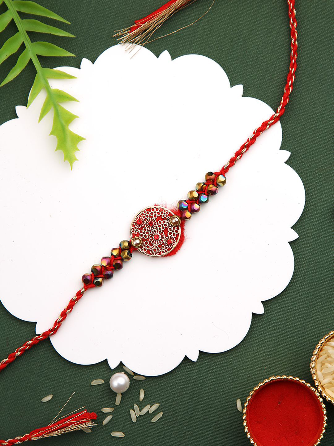 

Aapno Rajasthan Beaded Designer Thread Rakhi With Roli Chawal & Greetings Card, Red
