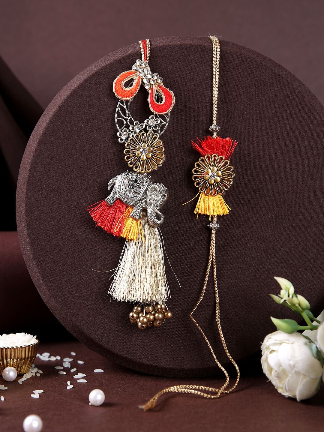 

Aapno Rajasthan Gold Plated Floral Bhaiya Bhabhi Rakhi With Roli Chawal & Greetings Card