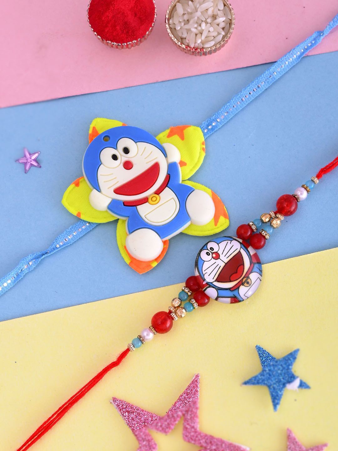 

Aapno Rajasthan Kids Set Of 2 Doraemon Thread Rakhis With Roli Rice & Greeting Card, Blue
