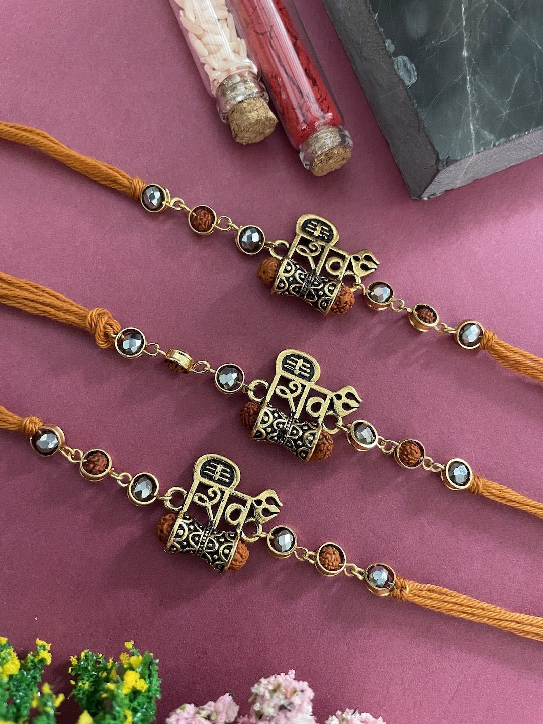 

Digital Dress Room Set Of 3 Shiva Damru & Rudraksh Thread Rakhi, Orange