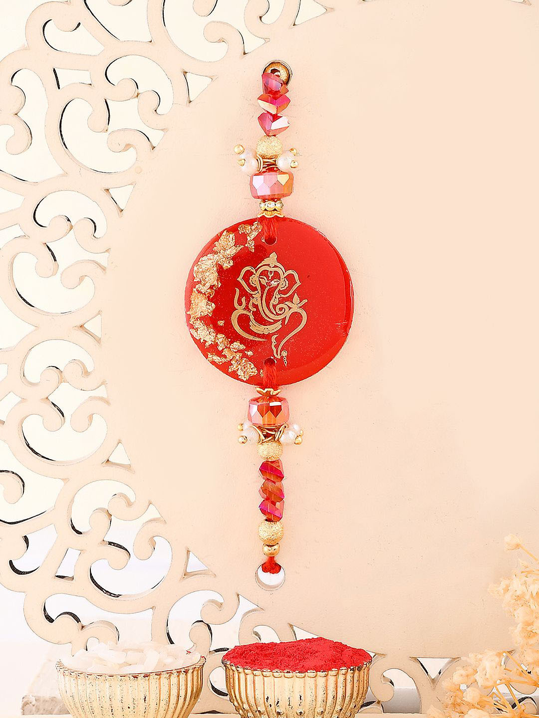 

Aapno Rajasthan Lord Ganesha Beaded Rakhi With Roli Chawal & Greetings Card, Red