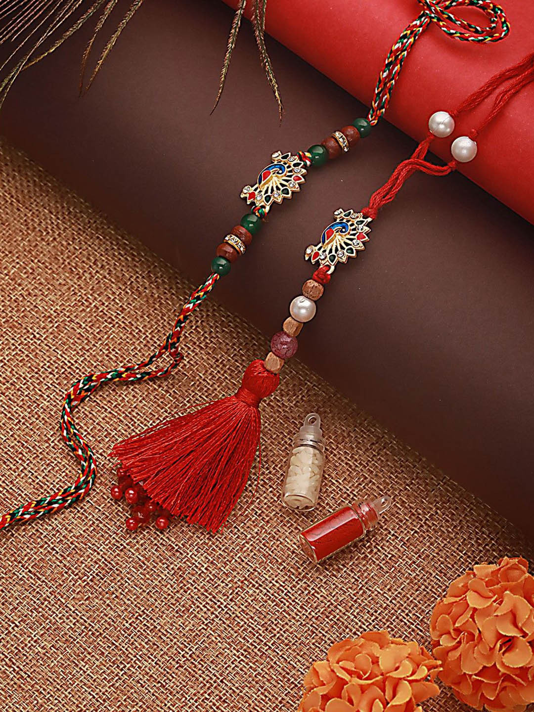 

Jazz and Sizzle Peacock Shaped Bhaiya Bhabhi Tasselled Rakhi with Roli & Chawal, Red
