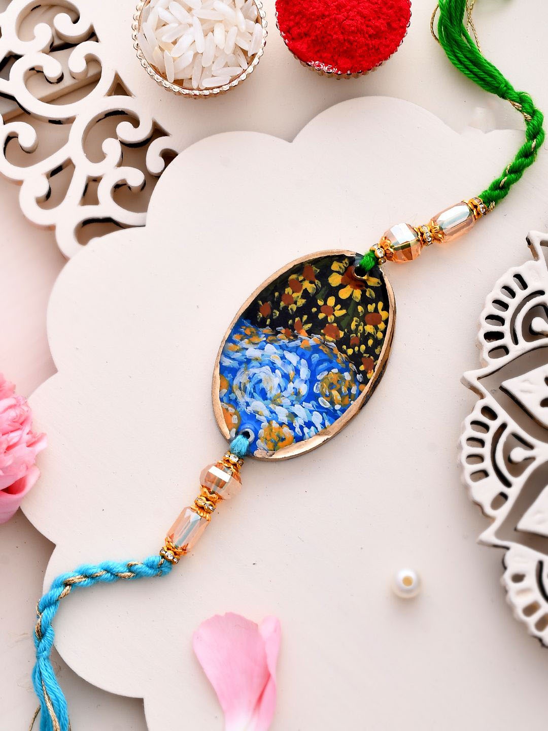

Aapno Rajasthan Beautiful Artwork of Flowers Thread Rakhi With Roli Chawal & Greeting Card, Blue