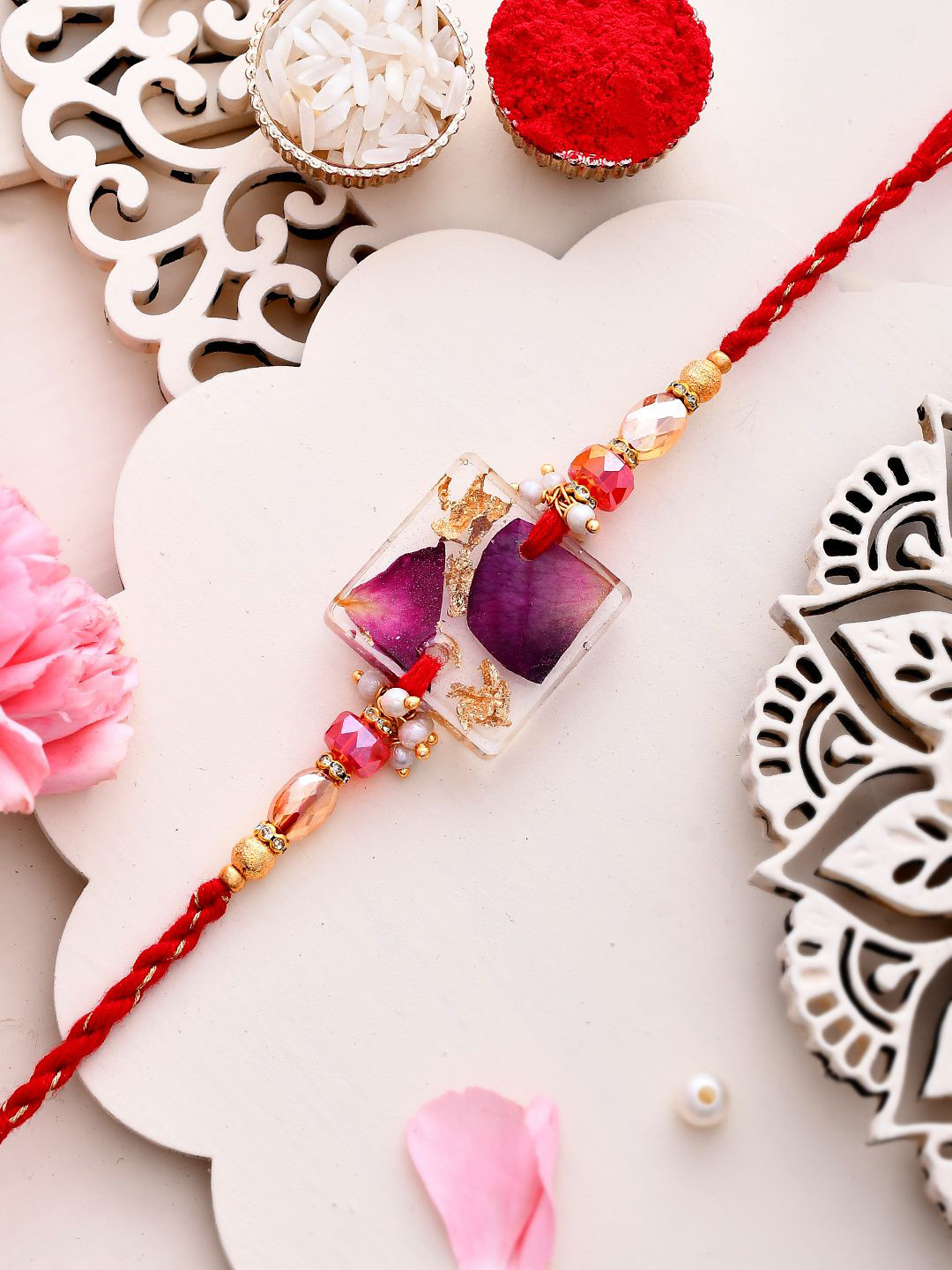 

Aapno Rajasthan Dried Rose Petal Resin Designed Twisted Thread Rakhi With Roli Chawal, Gold