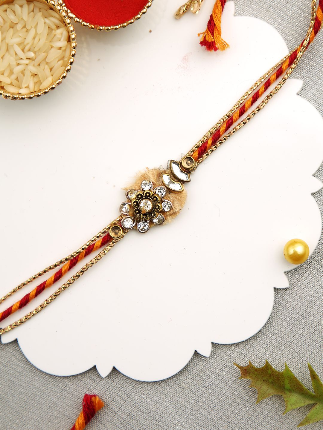 

Aapno Rajasthan Stones Studded Multistrand Rakhi With Roli Chawal & Greeting Card, Gold