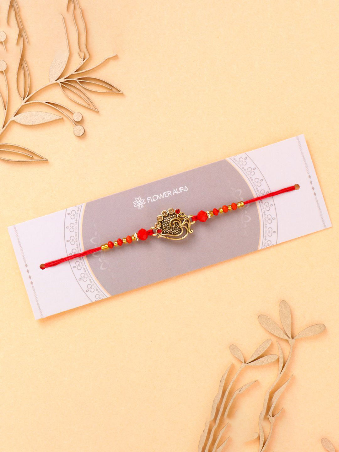 

Floweraura Beaded & Stone Studded Om Charm Thread Rakhi With Roli Chawal, Red