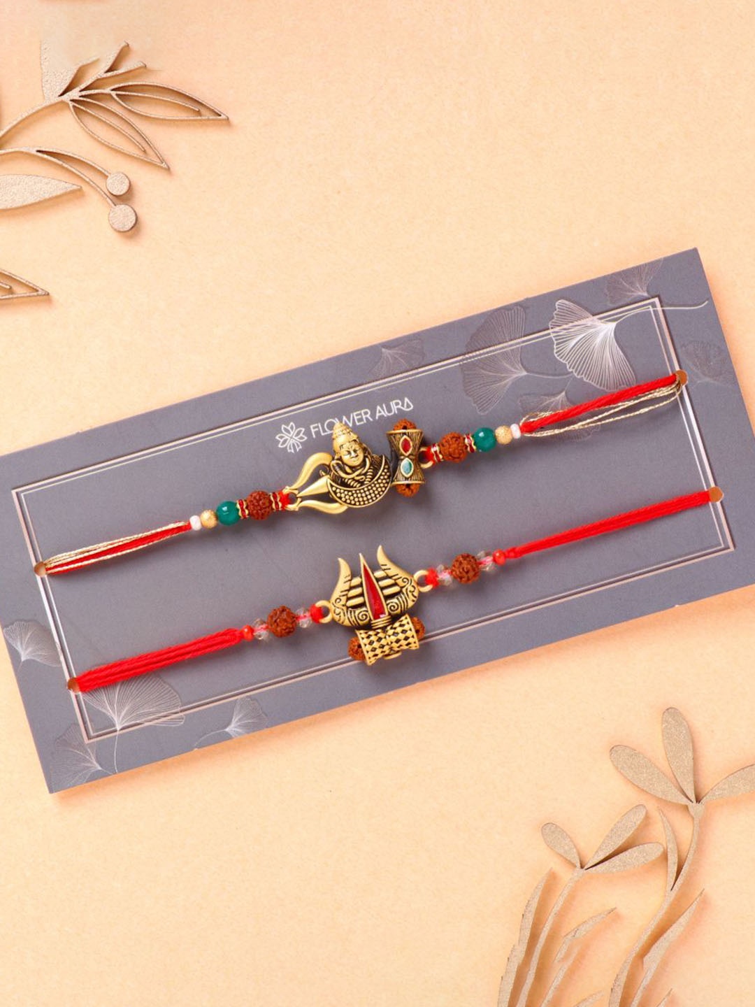 

Floweraura Set Of 2 Beaded Shiva and Damru Thread Rakhi With Roli Chawal, Red