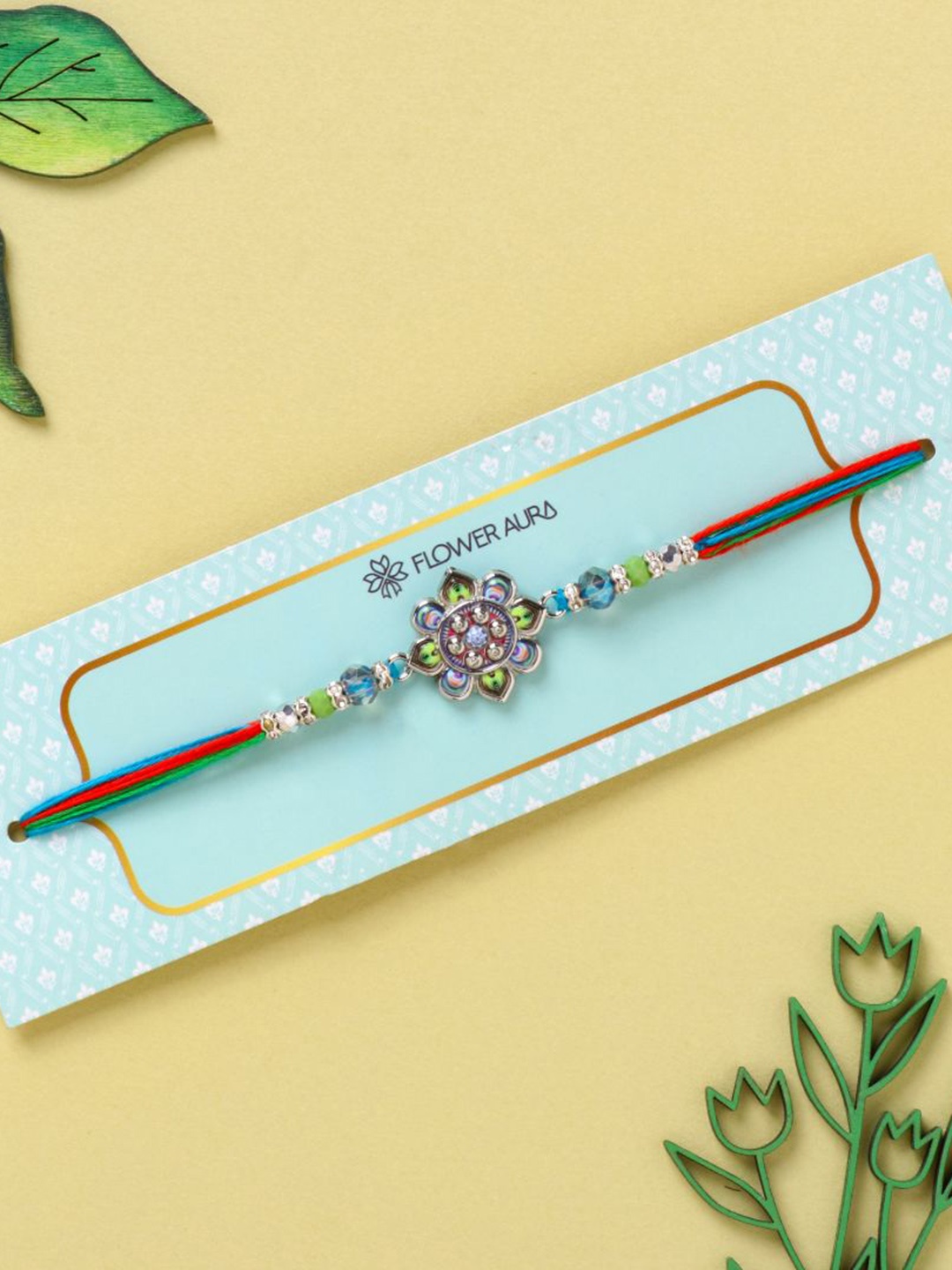 

Floweraura Floral Charm Thread Rakhi With Roli Chawal, Blue