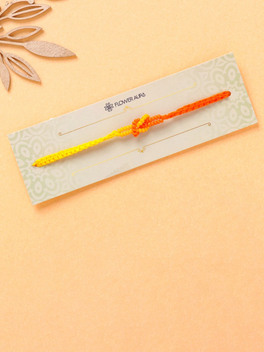 

Floweraura Vibrant Beaded Infinity Thread Rakhi With Roli Chawal, Yellow