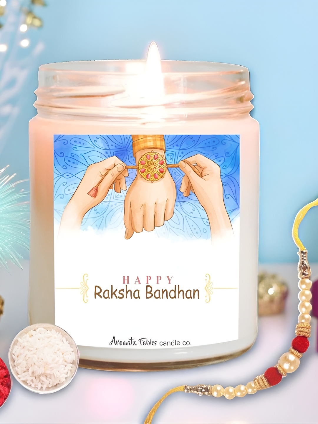 

Aromatic Fables Set Of 2 Rakhi With Velvet Rose Elegance Scented Candle & Roli Chawal, White