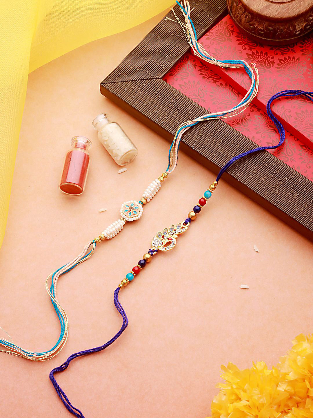 

Jazz and Sizzle Set of 2 Faux Pearl Beaded & Peacock Shaped Thread Rakhi With Roli Chawal, Blue