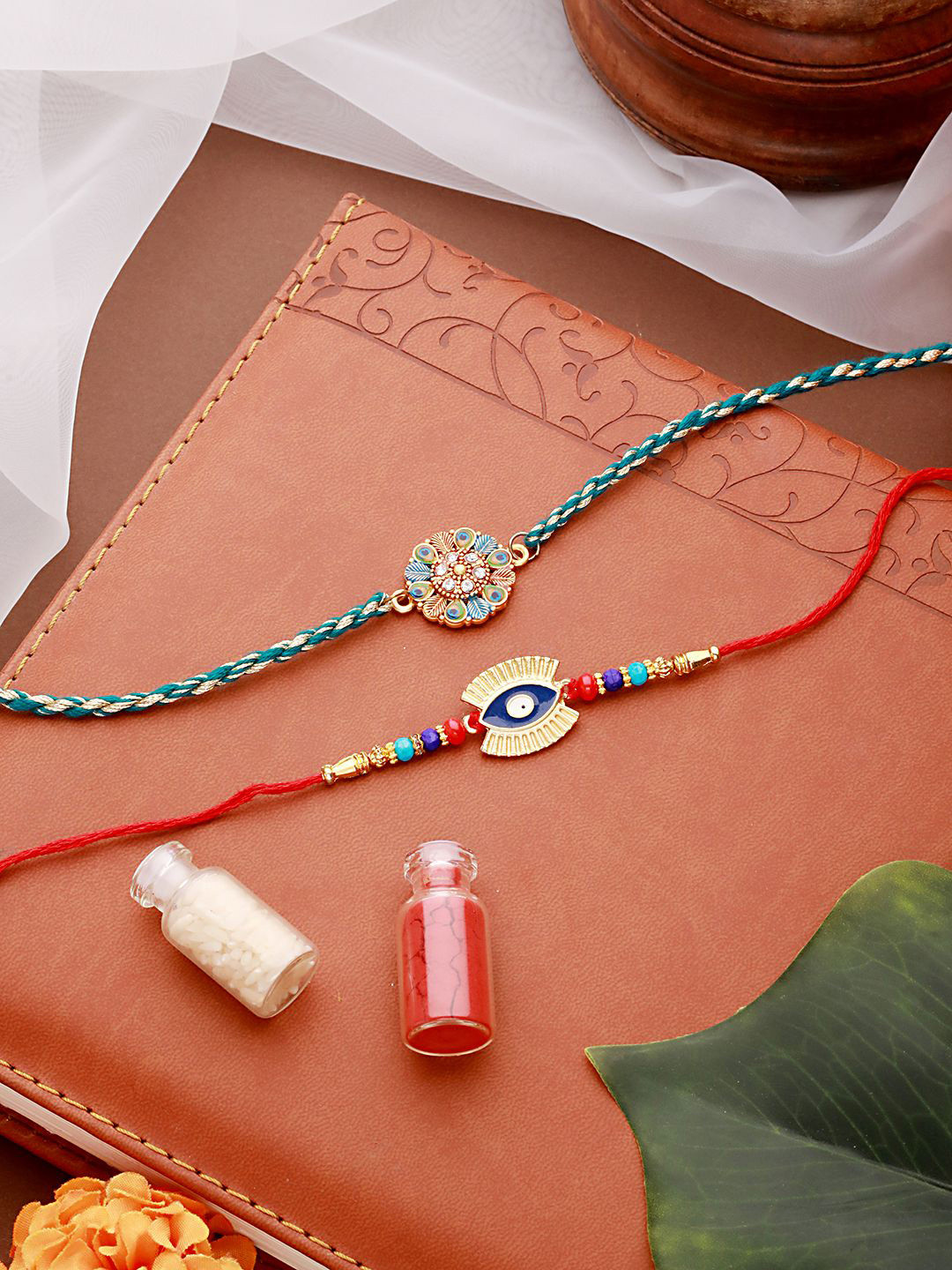 

Jazz and Sizzle Set of 2 Evil Eye & Leaf Meena Work Rakhi With Roli Chawal, Gold