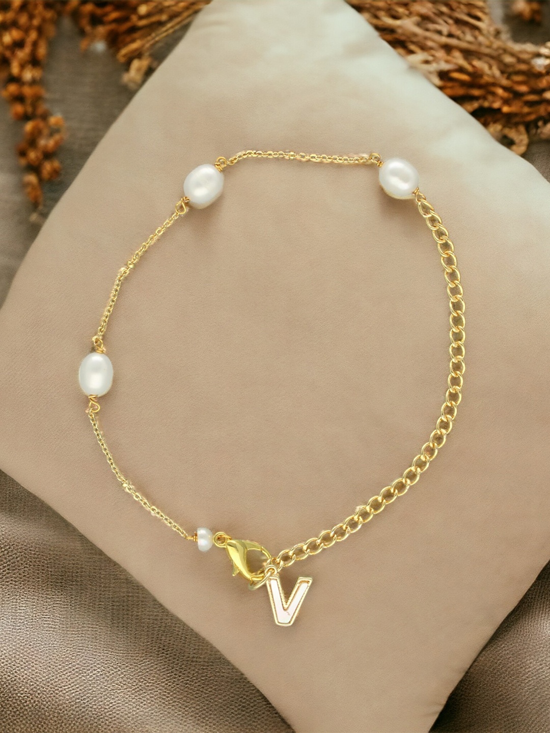 

Sri Jagdamba Pearls Dealer Gold-Plated Mother of Pearl Studded V Alphabet Charm Bracelet