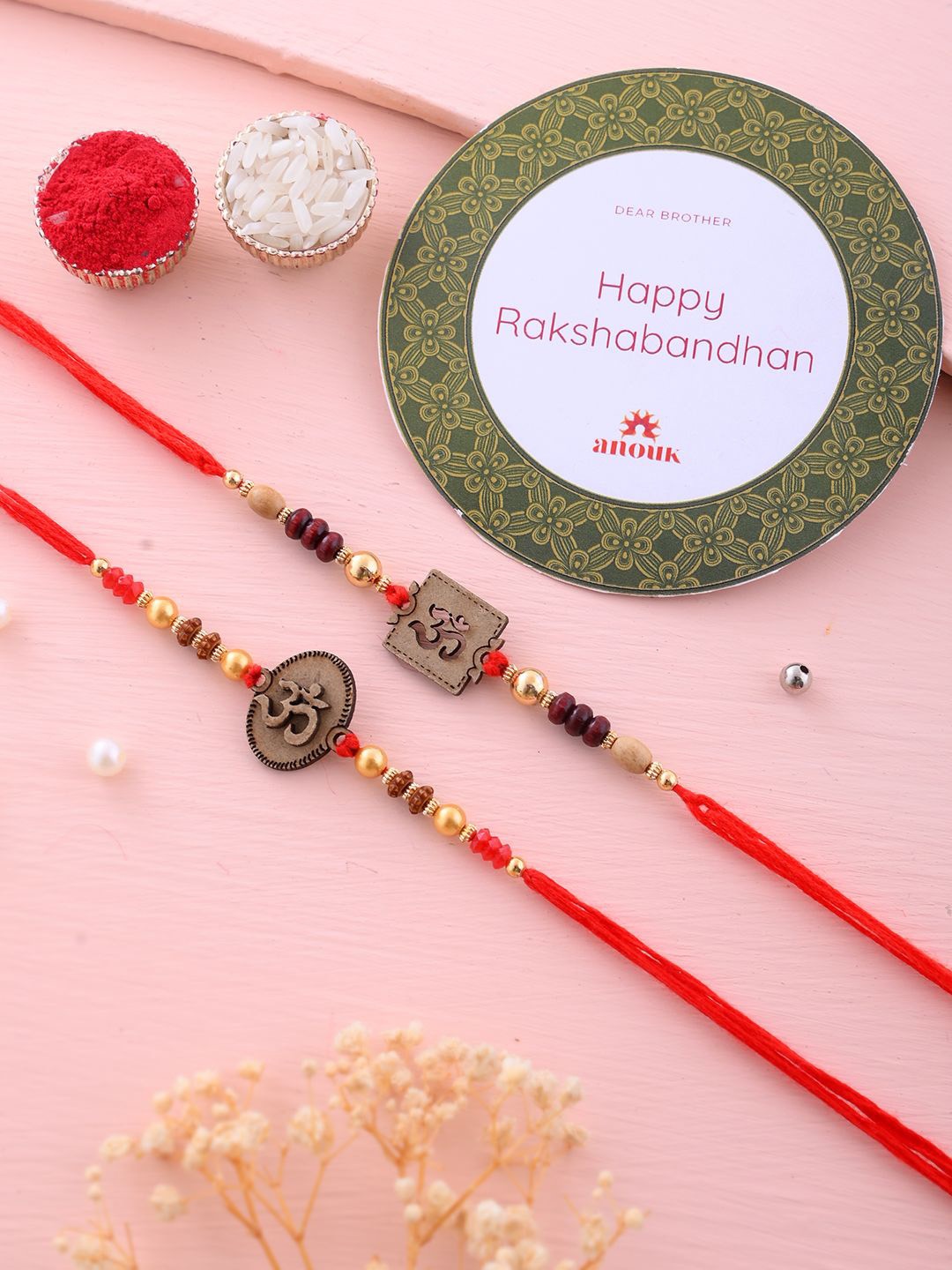 

Anouk Set Of 2 Red Wooden Om Beaded Rakhi With Roli Rice & Greeting Card, Gold