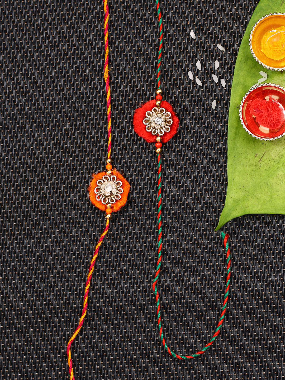 

Anouk Set Of 2 Red Flower Design Stone Studded Rakhis Comes With Roli Rice & Greeting Card