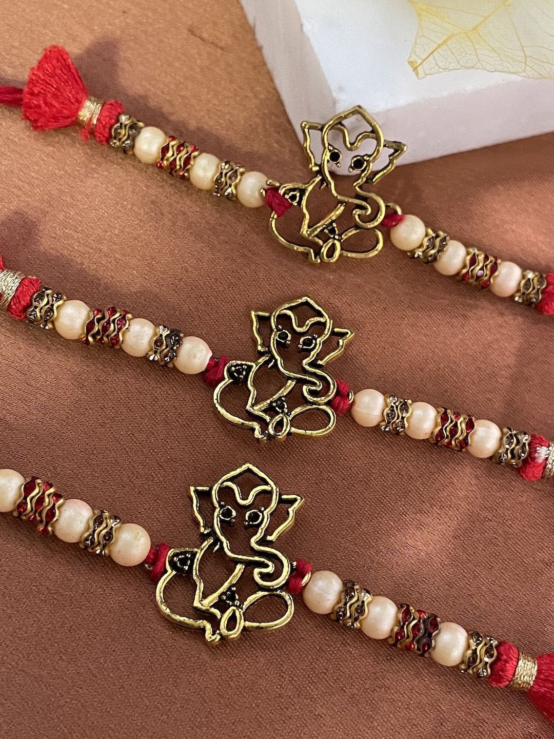 

Digital Dress Room Set Of 3 Ganesha With Beaded Thread Rakhi, Red