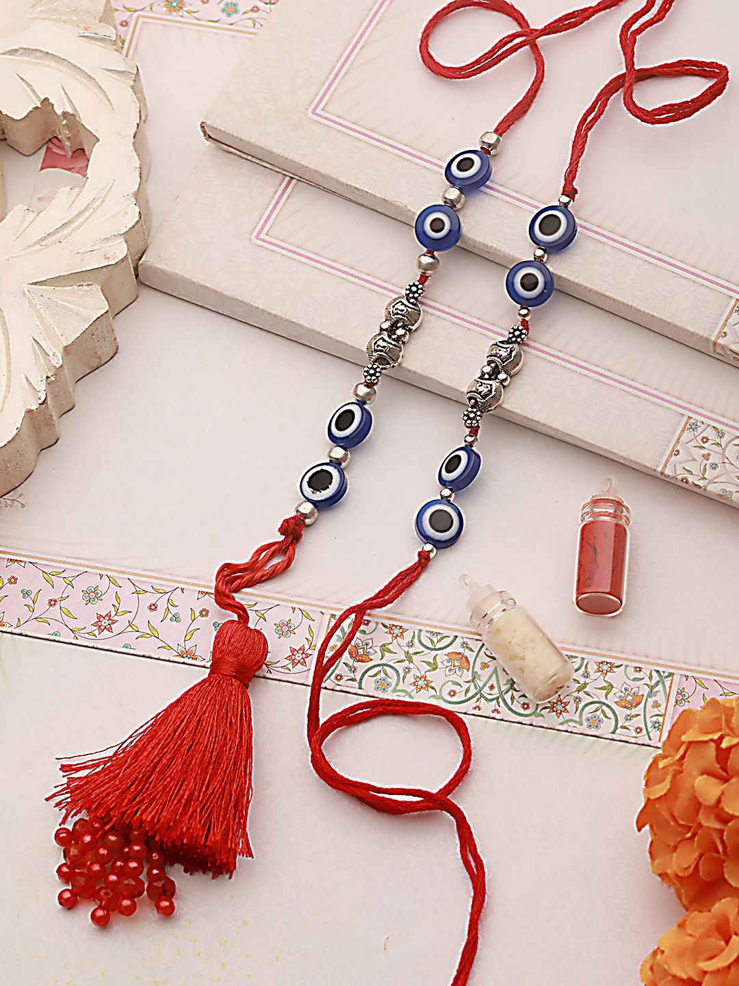 

Sangria Blue Set of 2 Evil Eye Tasselled Thread & Lumba Rakhis with Roli Chawal