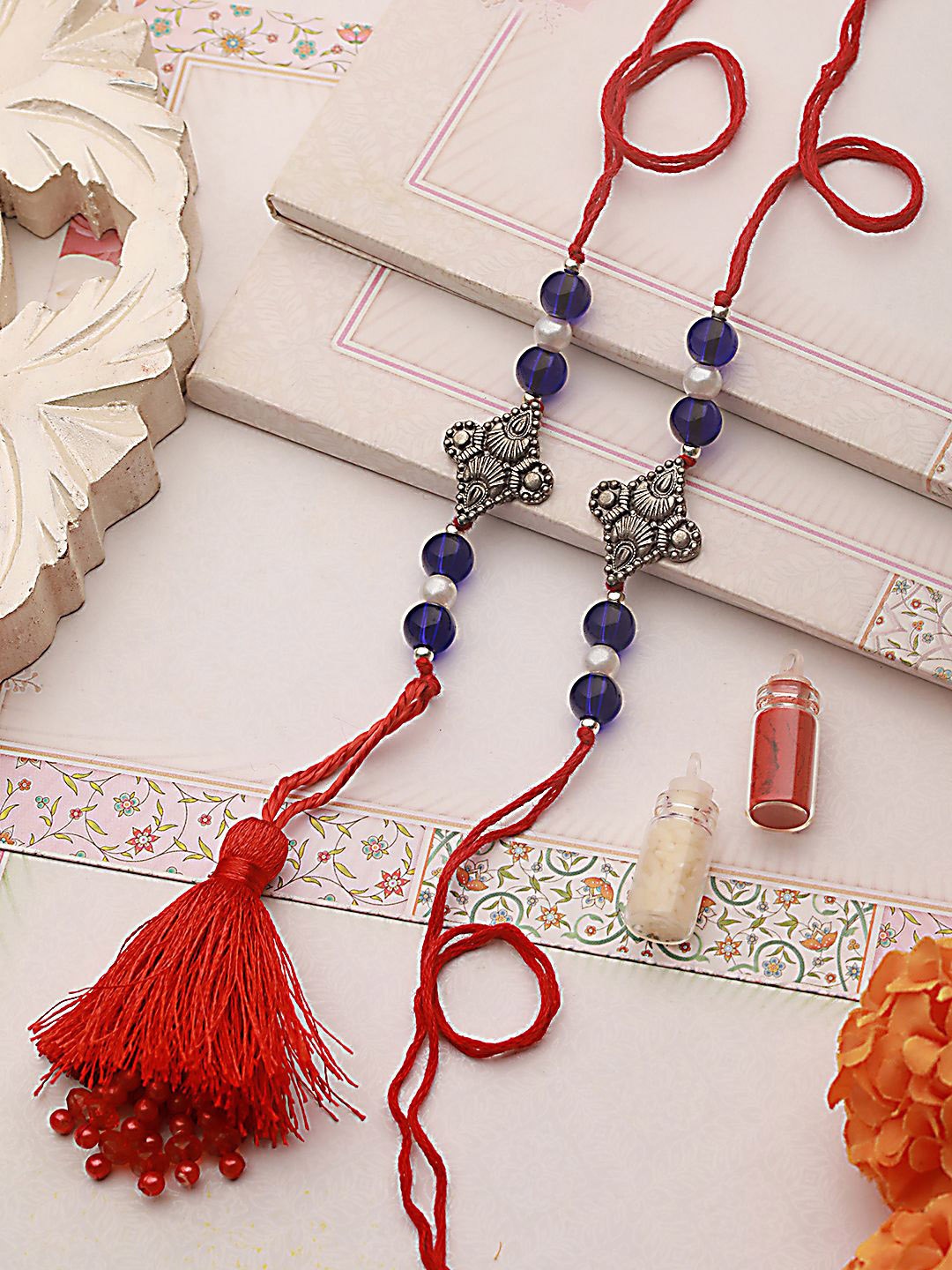 

Sangria Blue Set of 2 Pearl Beaded Tasselled Lumba & Thread Rakhis With Roli Chawal