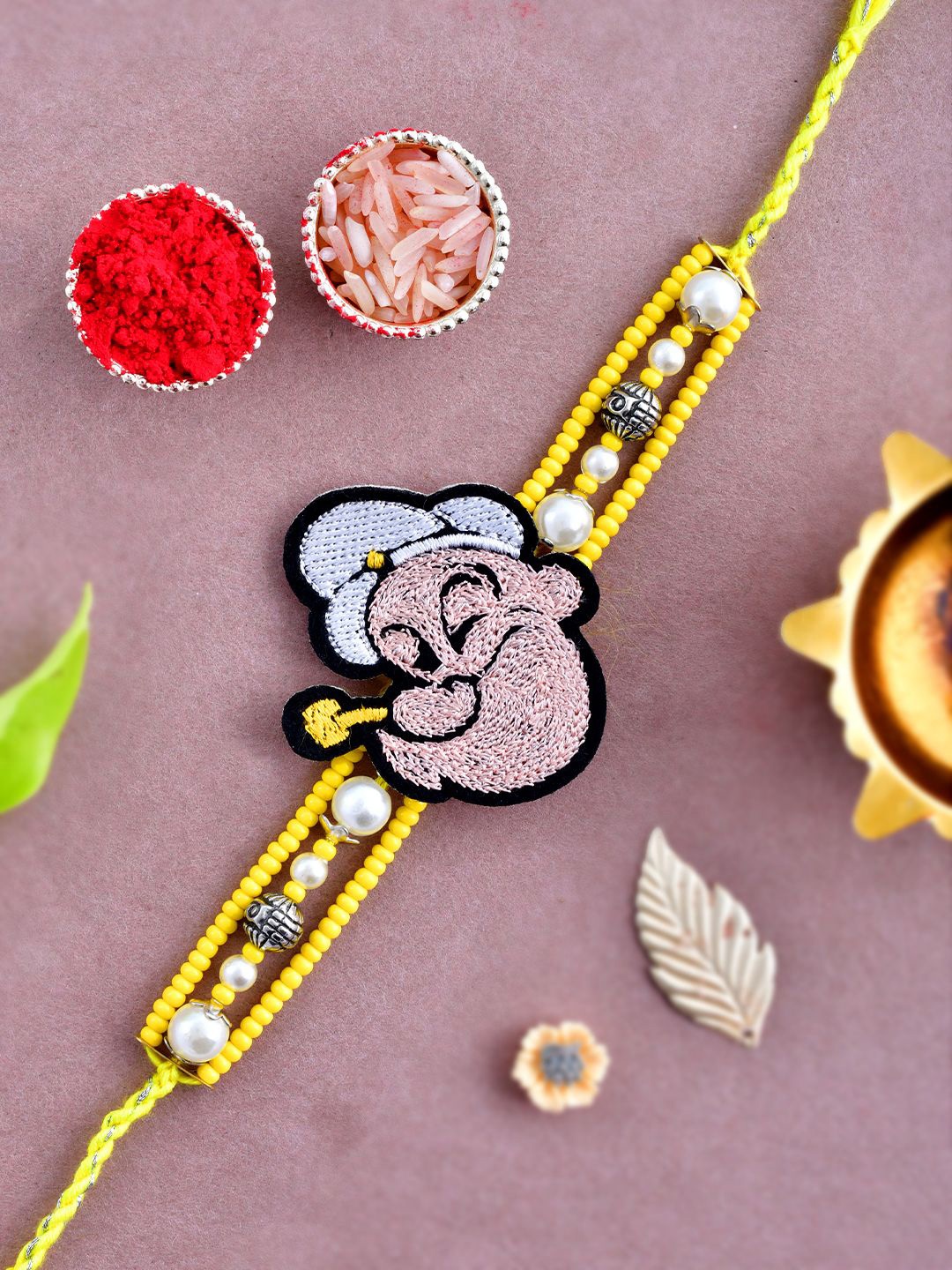 

Kook N Keech Yellow Beaded Popeye Thread Rakhi With Roli Chawal & Greetings Card