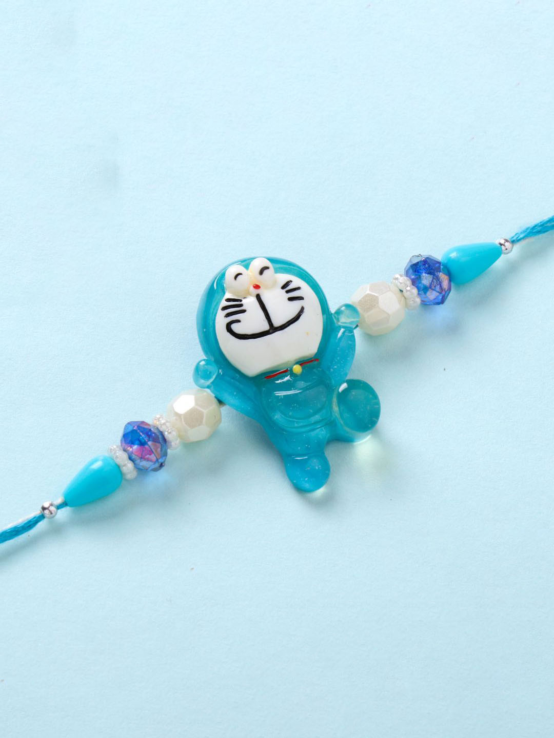 

Floweraura Boys Doraemon Thread Rakhi with Roli Chawal, Blue