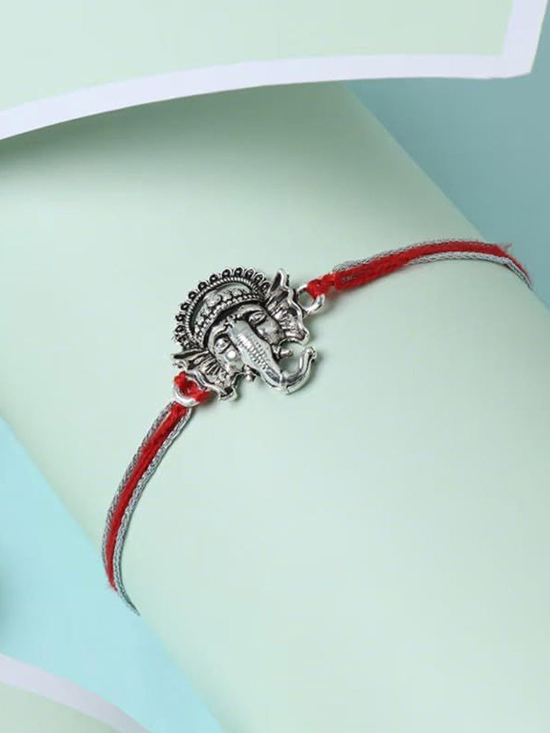 

Floweraura Lord Ganesha Thread Rakhi with Roli Chawal, Silver