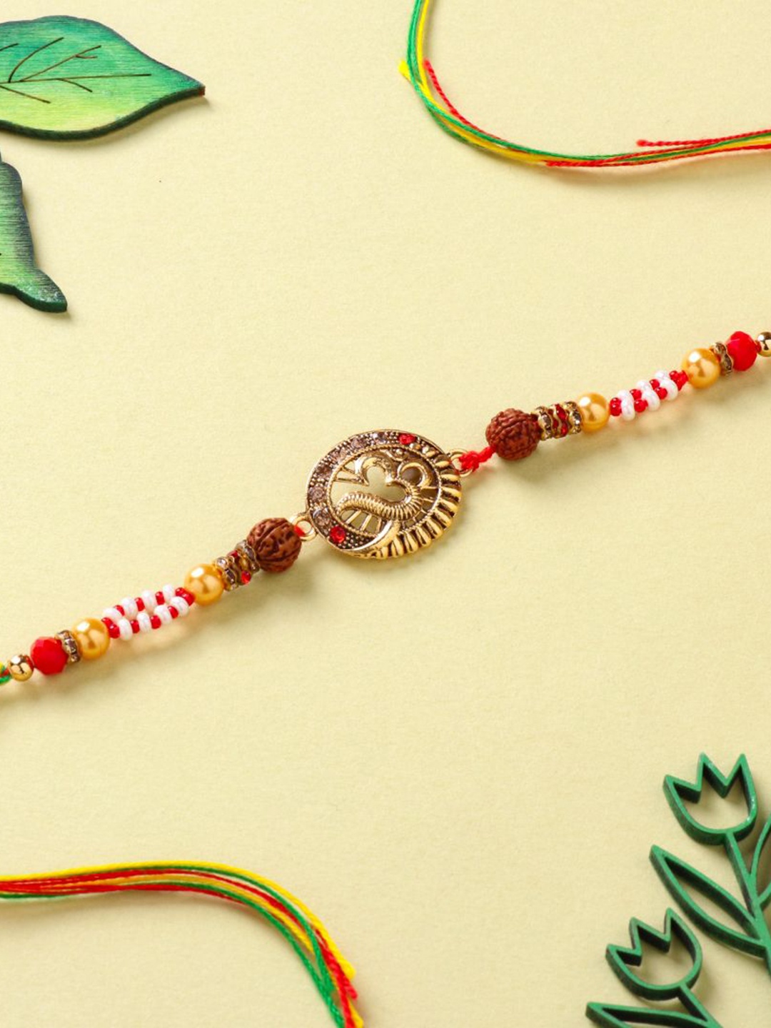 

Floweraura Om Rudraksha Charm Stone Studded & Beaded Thread Rakhi With Roli Chawal, Yellow