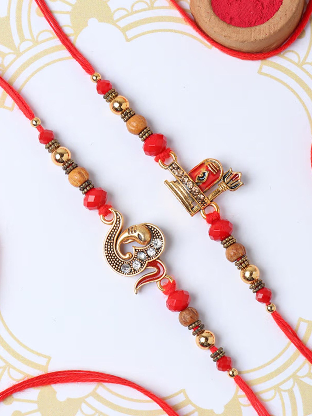 

Floweraura Set Of 2 Shivling & Om Ganesha Thread Rakhi With Roli & Chawal, Red