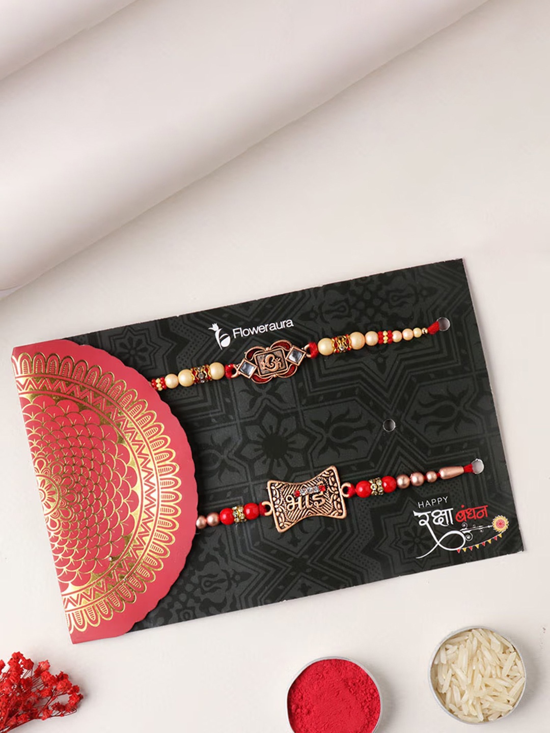 

Floweraura Set Of 2 Stone Studded & Beaded Thread Rakhis With Roli Chawal, Red