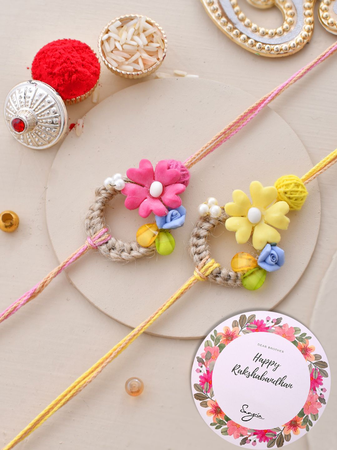 

Sangria Pink Set of 2 Floral Thread Rakhis With Greeting Card & Roli Chawal