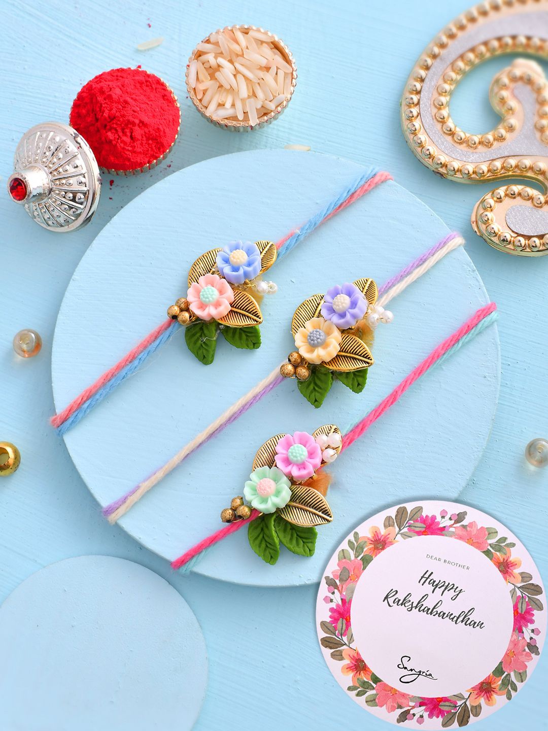 

Sangria Set Of 3 Floral Beaded Rakhi With Roli Chawal & Greeting Card, Pink