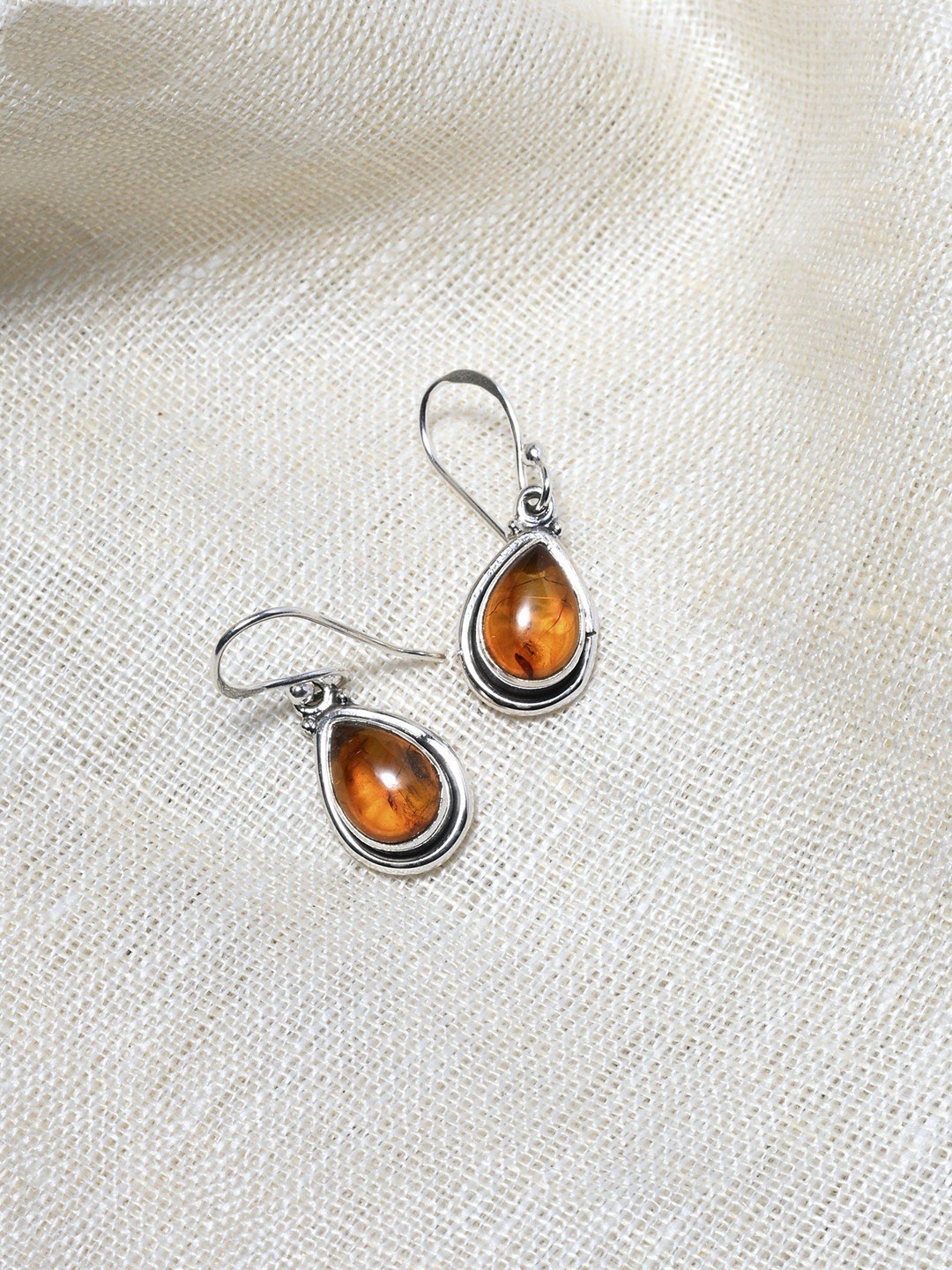 

Exotic India Sterling Silver Teardrop Shaped Amber Studded Drop Earrings