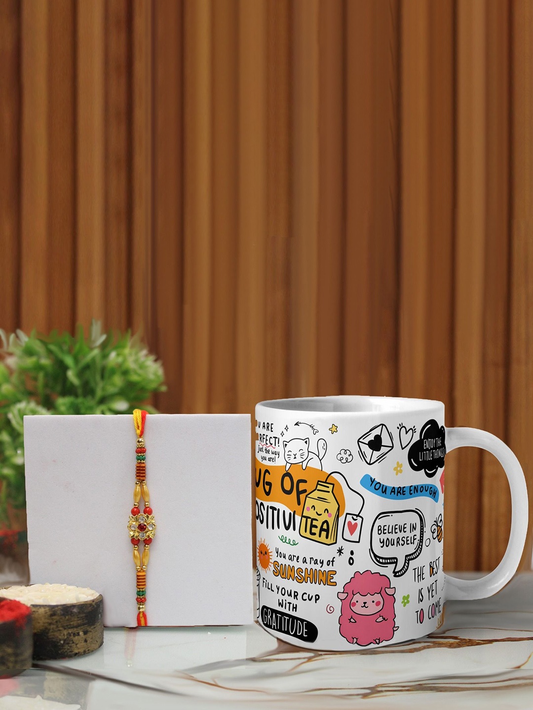 

Phirki Studio Set of 2 Stone Studded Thread Rakhi With Mugs & Roli Chawal, Yellow
