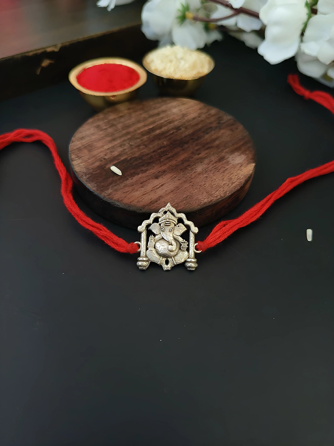 

Sangria Silver Plated Ganesha Rakhi With Roli Chawal