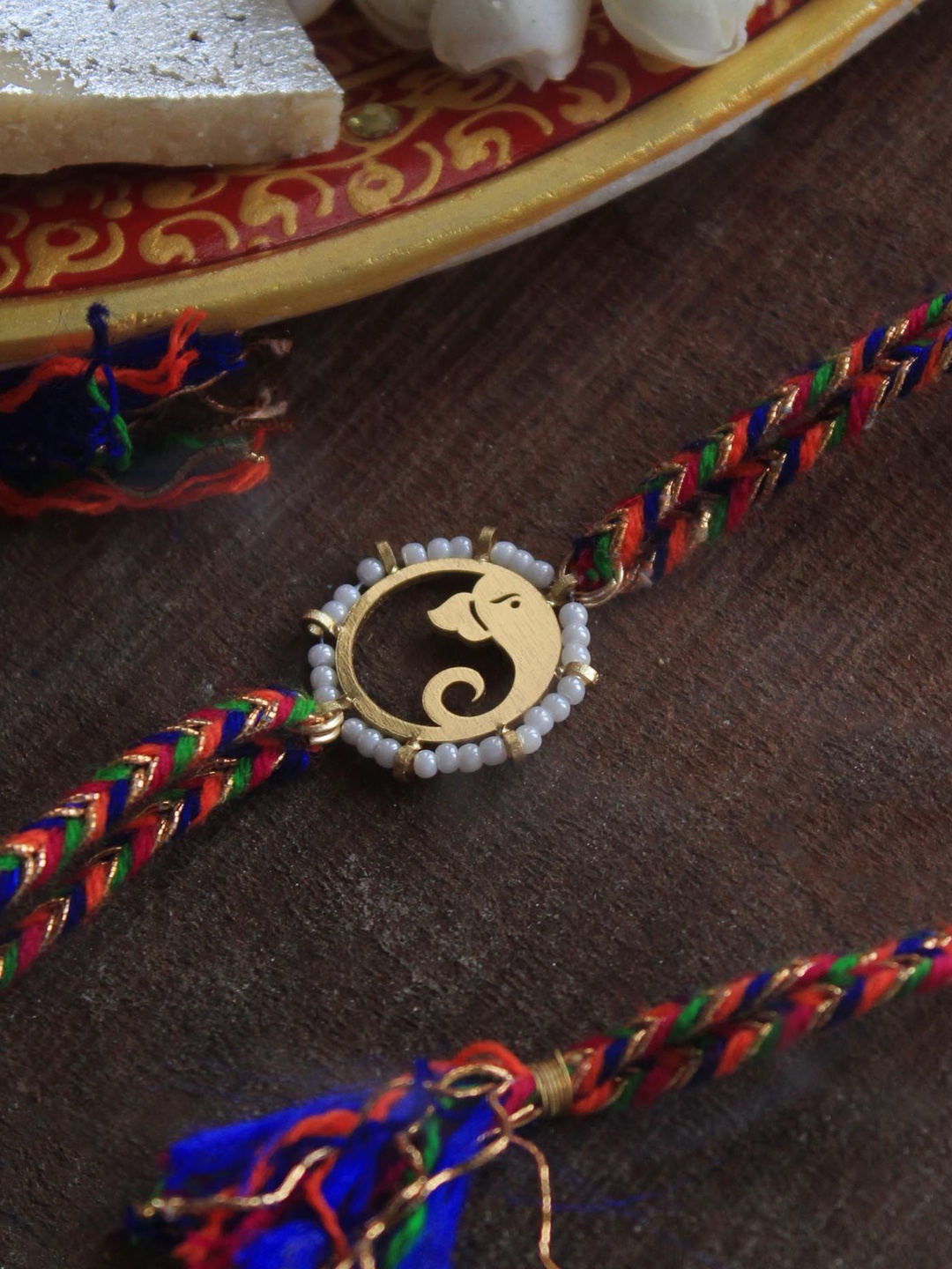 

BeAbhika Beaded Ganesha Charm Thread Rakhi With Roli Chawla, Gold