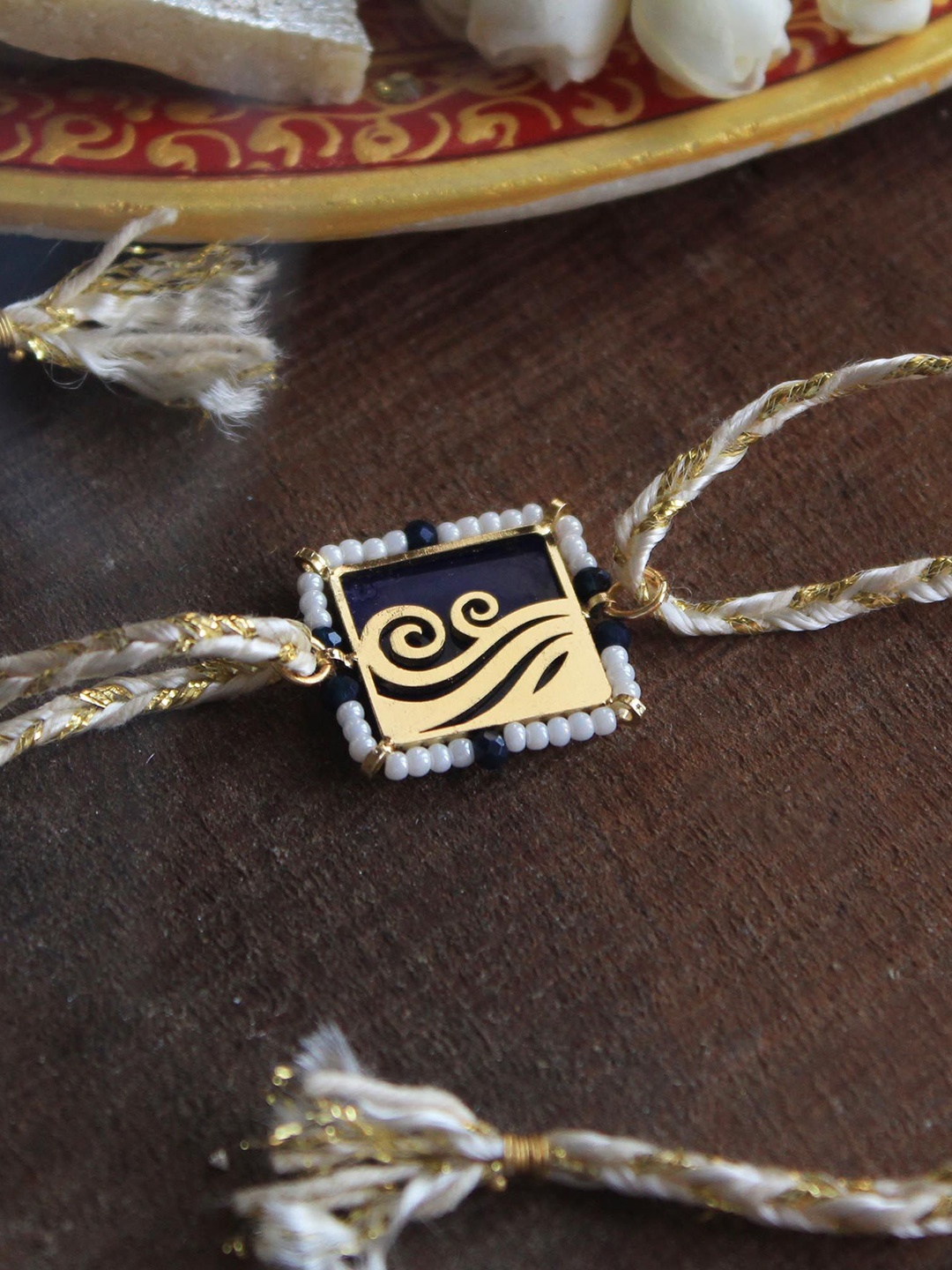 

BeAbhika Flowy Water Laser Cut Waves Rakhi With Roli Chawal Capsules, Blue