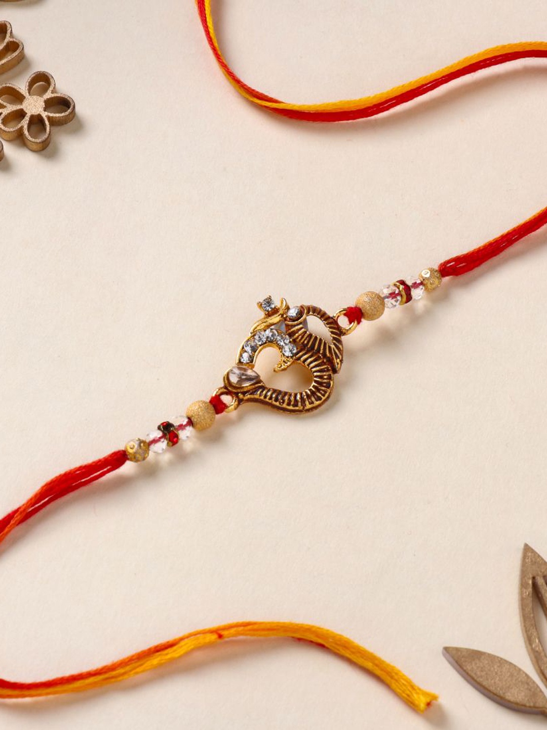 

Floweraura Om Charm Stone Studded & Beaded Thread Rakhi With Roli Chawal, Gold