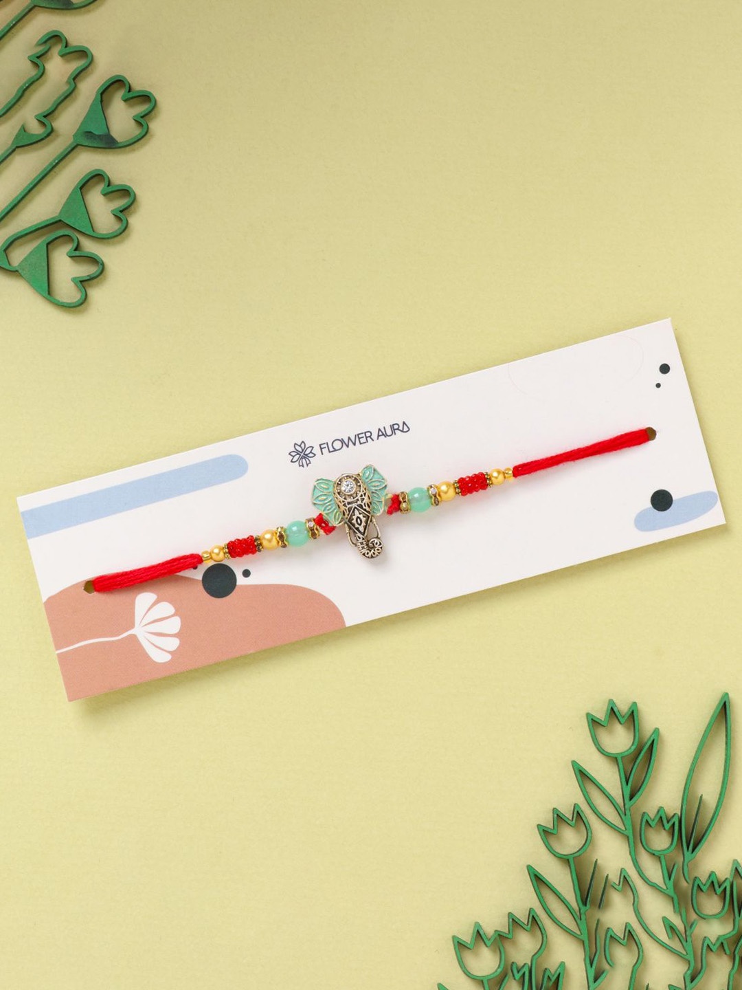 

Floweraura Elephant Charm Stone Studded & Beaded Thread Rakhi With Roli Chawal, Gold