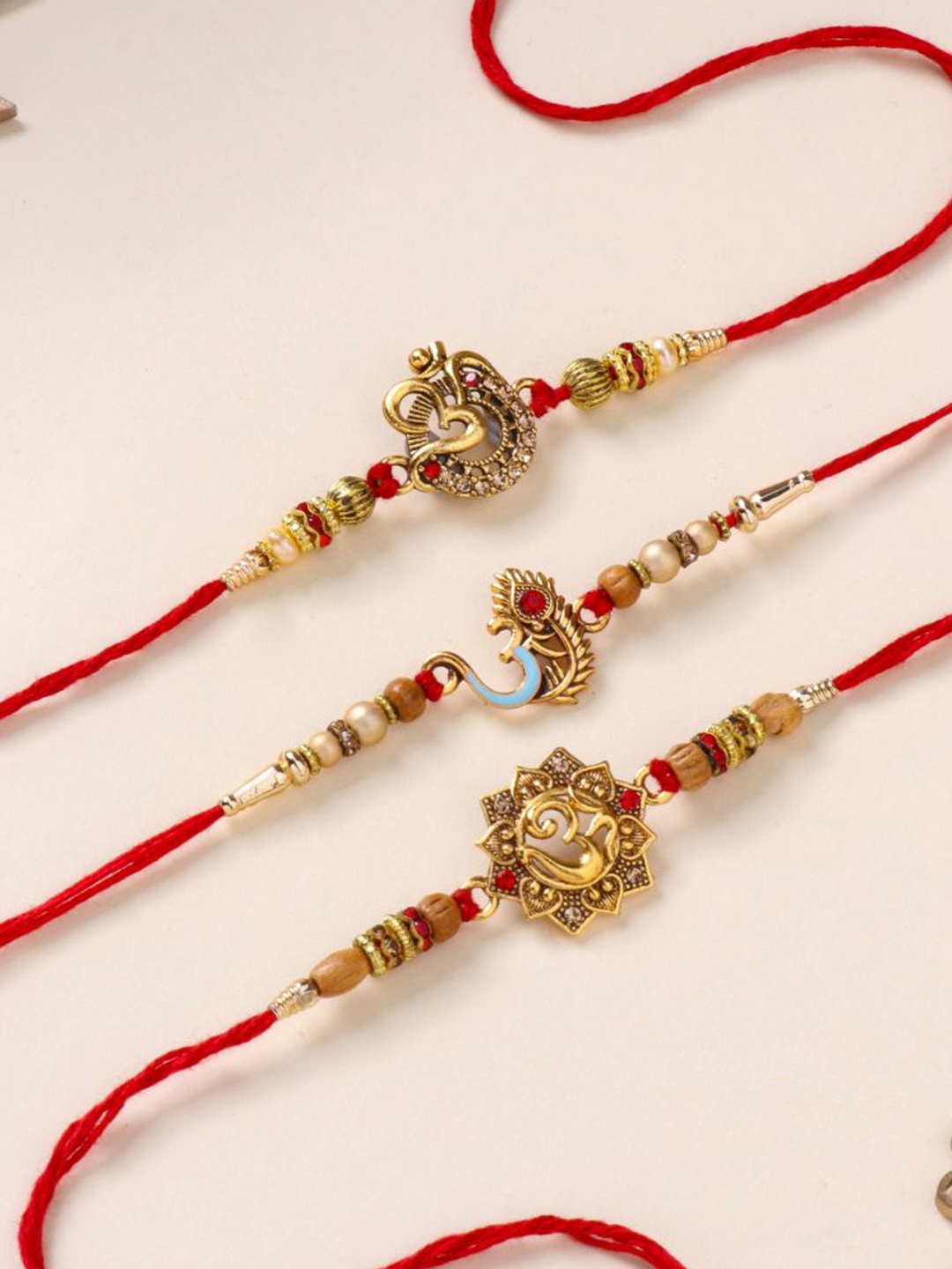 

Floweraura Set Of 3 Om Charm Stone Studded & Beaded Thread Rakhis With Roli Chawal, Gold